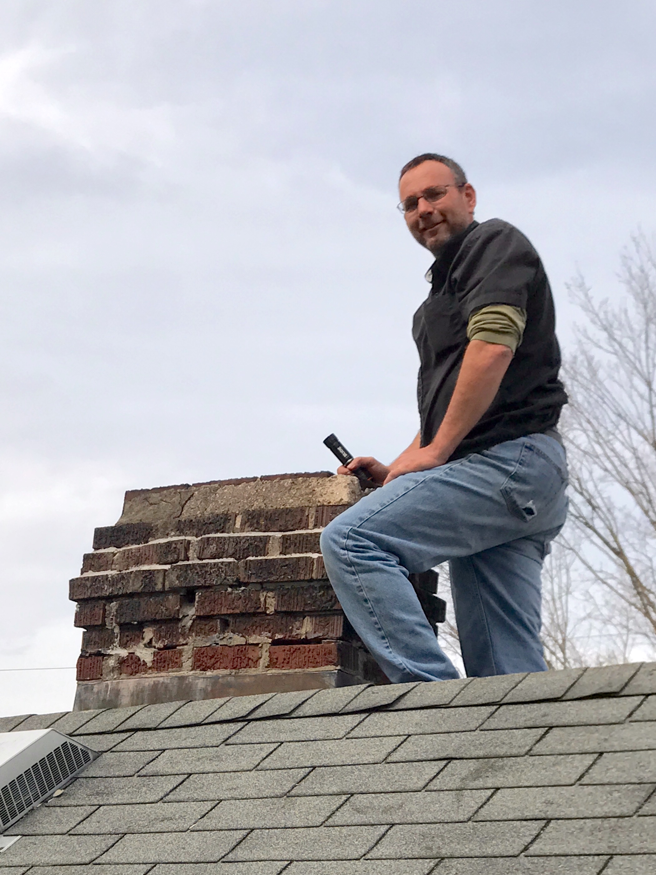 John Lawson of Assured Home Inspections inspecting the chimney and roof of a single-family home in Northern Kentucky